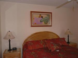 a bedroom with a bed and two lamps and a picture at Napili Point Oceanfront Turtle View 1BR - Unit B30 condo in Lahaina +6 photos