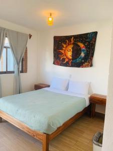 a bedroom with a bed with a painting on the wall at Casa AmaNacer Malinalco in La Ladrillera