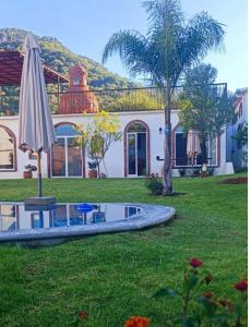 a garden with an umbrella and a fountain at Casa AmaNacer Malinalco in La Ladrillera +6 photos