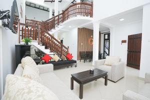 a living room with white furniture and a staircase at lumiere south Residence in Matara