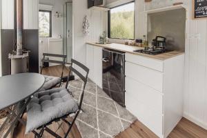 a kitchen with a table and a table and chairs at Te Paki Dam View X by Tiny Away in Sanson