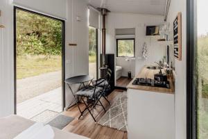 a kitchen and living room of a tiny house at Te Paki Dam View X by Tiny Away in Sanson