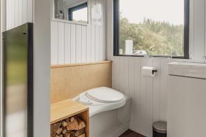 a small bathroom with a toilet and a window at Te Paki Dam View X by Tiny Away in Sanson +27 photos