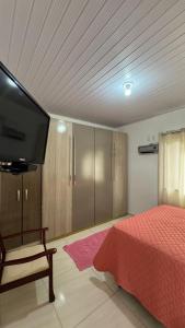 a bedroom with a bed and a flat screen tv at Casa Turista in Cambará