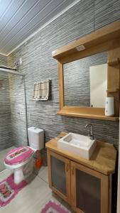 a bathroom with a sink and a toilet and a mirror at Casa Turista in Cambará