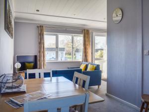a living room with a table and a blue couch at Alula Lodge in Lowestoft