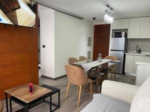 a kitchen and a living room with a table and chairs at Puerto Montt centro 2 diagonal Germania in Puerto Montt