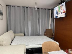a room with a bed and a flat screen tv at Puerto Montt centro 2 diagonal Germania in Puerto Montt