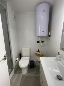 a white bathroom with a toilet and a sink at Puerto Montt centro 2 diagonal Germania in Puerto Montt