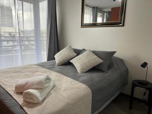 a bedroom with a bed with a mirror on the wall at Puerto Montt centro 2 diagonal Germania in Puerto Montt