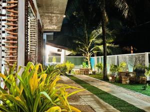 a garden with chairs and palm trees and a building at KOKO Villa in Kochchikade