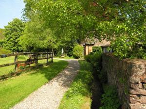 a stone wall next to a road next to a fence at Annexe- Ukc4917 in Timberscombe