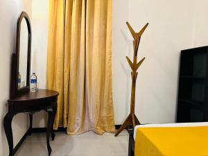 a room with a table and a yellow curtain at KOKO Villa in Kochchikade +89 photos