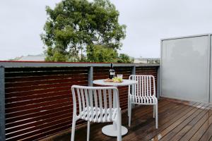 two chairs and a table on a deck at Punthill Williamstown in Williamstown