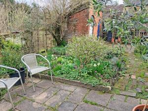 a patio with two chairs and a garden at Sunnyside in Yoxford