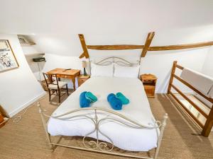 a bedroom with a bed with blue slippers on it at Sunnyside in Yoxford