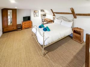 a bedroom with a white bed and a television at Sunnyside in Yoxford