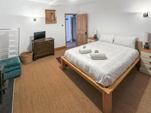 a bedroom with a large bed and a television at Sunnyside in Yoxford