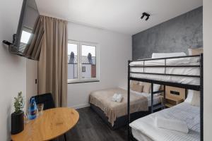 a small room with two bunk beds and a table at Apartamenty Racławicka Mszczonów in Mszczonów