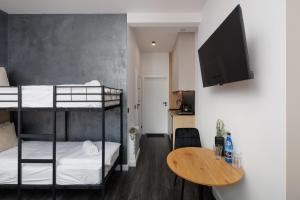 a small room with two bunk beds and a table at Apartamenty Racławicka Mszczonów in Mszczonów