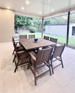 a wooden table and chairs on a patio at Rainbow House in Rainbow Beach