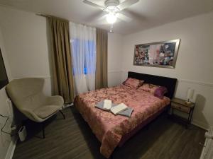 a bedroom with a bed and a chair and a window at Brossard home2 in Brossard