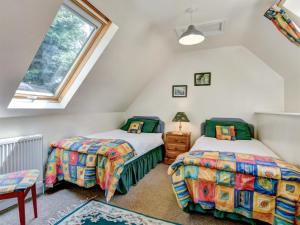a attic bedroom with two beds and a window at Annexe- Ukc4917 in Timberscombe