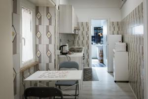 a kitchen with a table and chairs and a refrigerator at Casa FONTE GRANDE a due passi dalla Clinica "Immacolata" in Celano