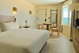 a hotel room with a bed and a table and chairs at Ambros Daytona, Trademark Collection by Wyndham in Daytona Beach +32 photos
