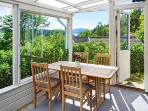 a wooden table and chairs on a porch with a view at Comfortable Apartment Near Stenungsund in Munkedal