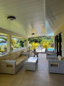 ein Wohnzimmer mit Sofas, Tisch und Stühlen in der Unterkunft Rainforest Valley in Mataiea