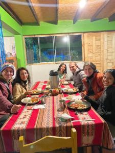 a group of people sitting around a table with food at Hanging Nest Salkantay in Colcapampa +99 photos