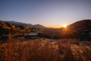 a view of the sun setting over a mountain at Kahutara PurePod in Kaikoura