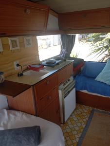 a kitchen with a sink and a stove in an rv at Cosy Caravan in Takaka