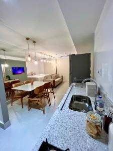 a kitchen and living room with a table and a couch at Azure Aesse Hospitality Marista in Goiânia