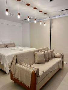 a bedroom with a bed and a couch in it at Azure Aesse Hospitality Marista in Goiânia +17 photos