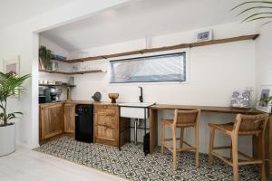 eine Küche mit schwarzem Kühlschrank und Holzschränken in der Unterkunft Lemon Tree Studio in Beechworth + 10 Fotos