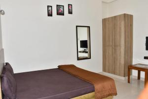 a bedroom with a bed and a mirror at Zeeenu Abode Yercaud by GD in Yercaud