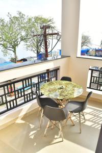 a dining room with a table and chairs and a balcony at Zeeenu Abode Yercaud by GD in Yercaud
