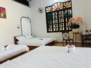 a room with two beds and a table with flowers at Gilan Boutique Hotel in Tân Phú +21 photos
