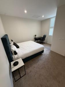 a bedroom with a bed and a desk and a chair at Belmore Living in Goulburn