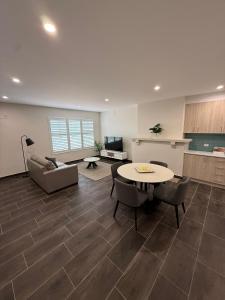 a living room with a table and chairs and a kitchen at Belmore Living in Goulburn