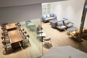 Blick in ein Wohnzimmer mit Stühlen und Tischen in der Unterkunft 루나스카이돔 구 스페이스앤무드 in Busan