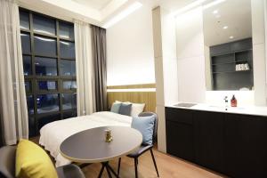 ein Schlafzimmer mit einem Bett, einem Waschbecken und einem Tisch in der Unterkunft 루나스카이돔 구 스페이스앤무드 in Busan + 86 Fotos