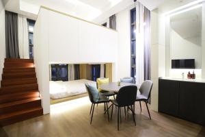 ein Esszimmer mit Tisch und Stühlen und ein Schlafzimmer in der Unterkunft 루나스카이돔 구 스페이스앤무드 in Busan