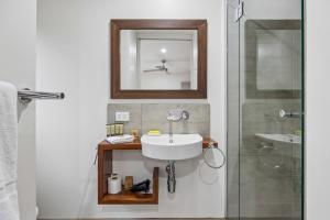 a bathroom with a sink and a mirror and a shower at Roses Creek Chalet B in Crackenback +20 photos