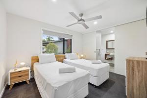 a bedroom with two beds and a ceiling fan at Roses Creek Chalet B in Crackenback