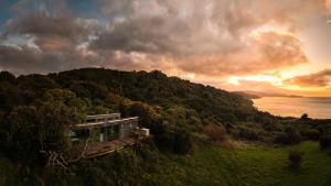 a house on top of a hill near the water at Tokoeka PurePod in Stewart Island