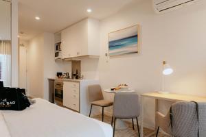 a room with a bed and a table and a kitchen at Punthill Williamstown in Williamstown