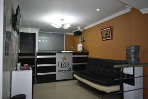 a hair salon with a black leather couch in a room at Ayenda Balcon Real in Tunja